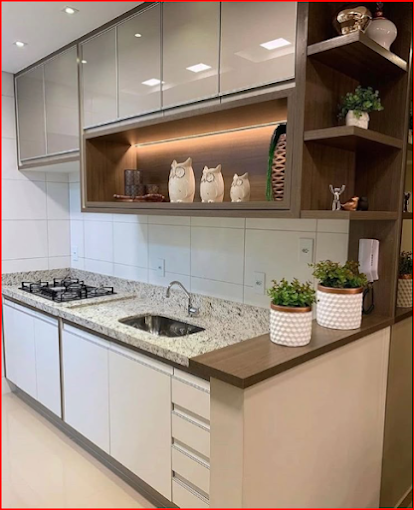 Cozinha planejada com armários brancos, nicho decorativo iluminado e prateleiras laterais em Resende
